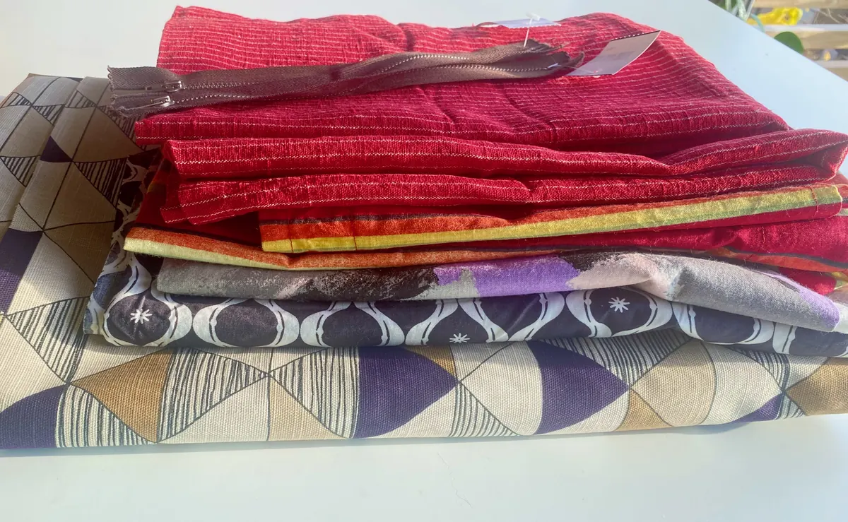 A folded stack of red, gold and patterned fabric