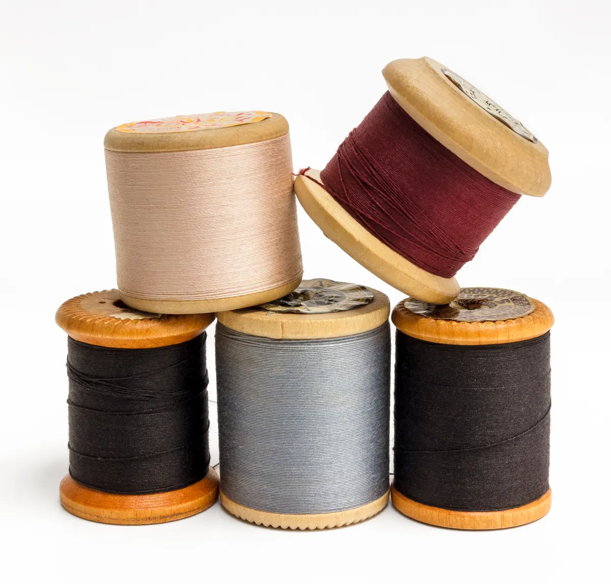 Wooden spools of thread in cream, wine red, grey and black